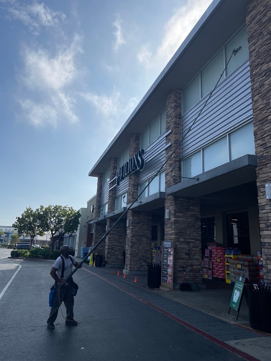 Evans Dynamic cleaning upper windows at a Pavilions storefront